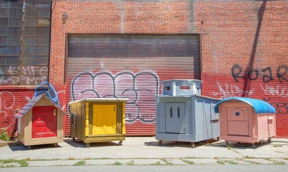artista transforma cacambas de lixo em pequenas casas para desabrigados